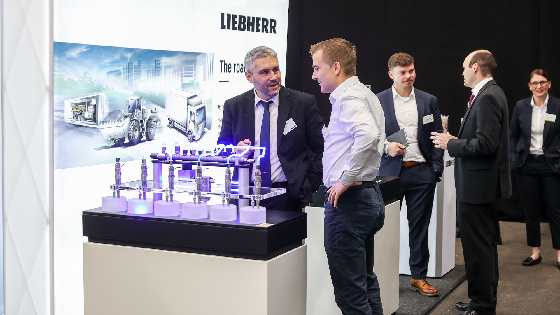 Zwei Herren betrachten ein Exponat im Ausstellungsbereich. 