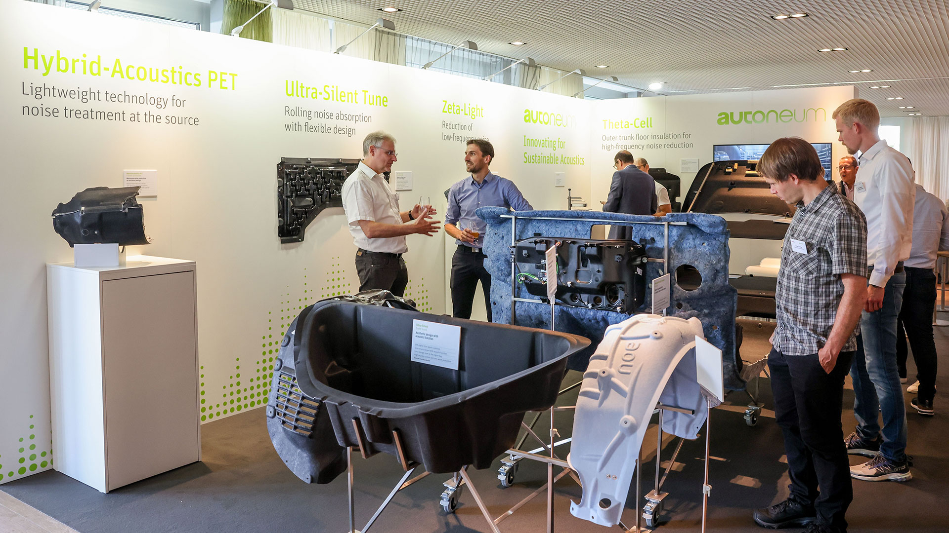 Gruppen von Konferenzteilnehmern unterhalten sich im Ausstellungsbereich.