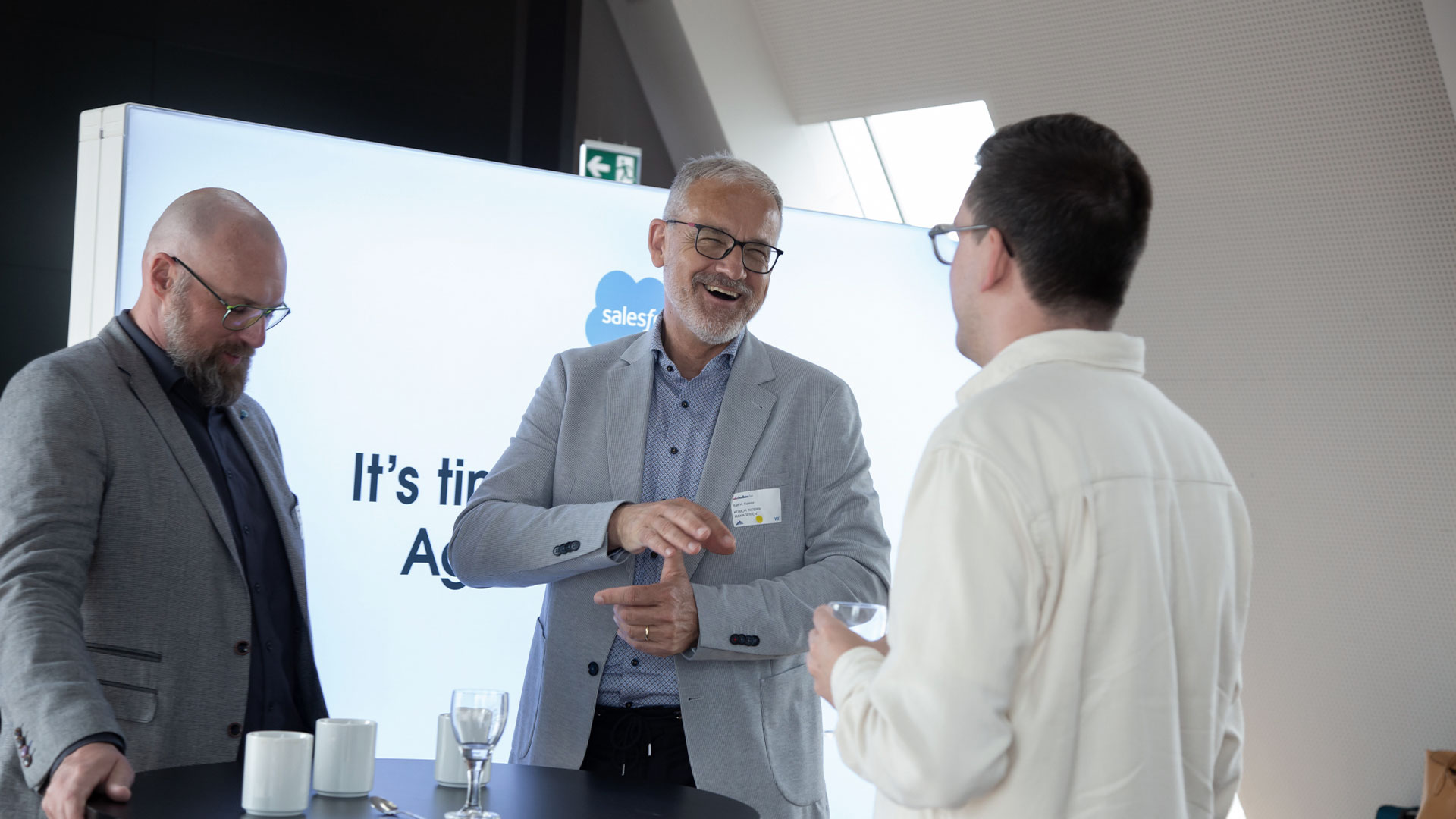 Drei Konferenzteilnehmer im Gespräch im Ausstellungsbereich