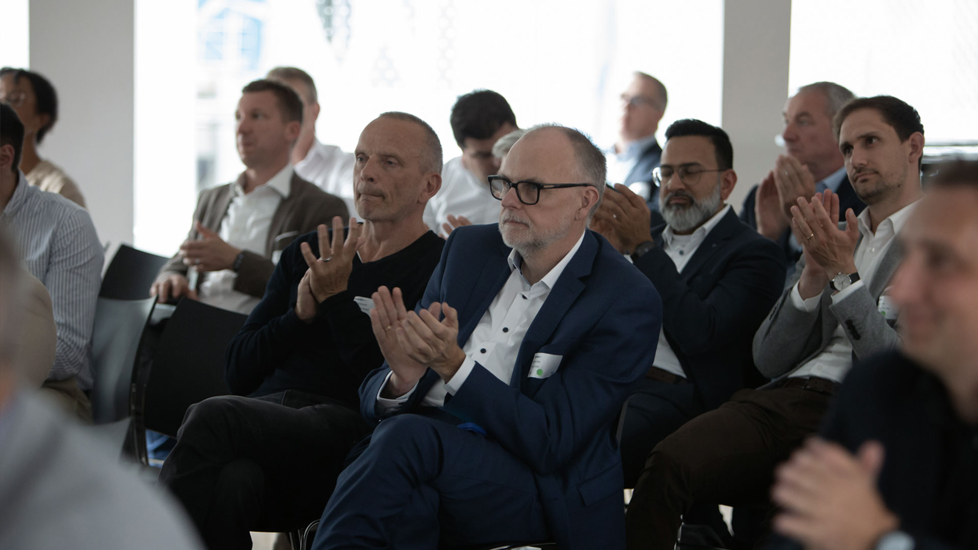 Klatschende Konferenzteilnehmer sitzend im Veranstaltungsraum